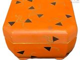 une boîte orange ornée de motifs noirs et dorés