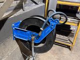 une photo d'un coupe-tube bleu à côté d'une pile de pneus