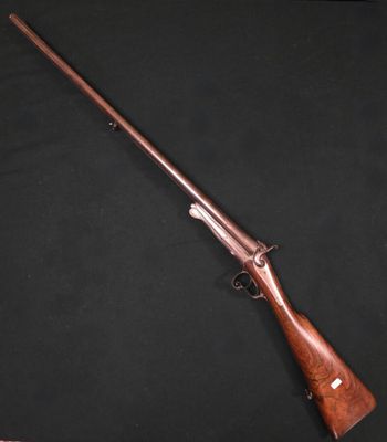 un fusil avec un canon et une crosse en bois, sur fond noir