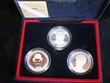 three silver coins in a red box on a black surface