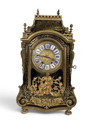 a gold clock that is sitting on a white surface