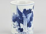 a blue and white vase with a waterfall in the background