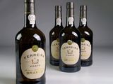 quatre bouteilles de vin sont alignées sur une surface blanche
