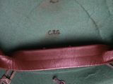a close up of a green bag with a brown handle