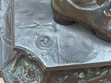 a bronze statue of a woman ' s feet on top of a book