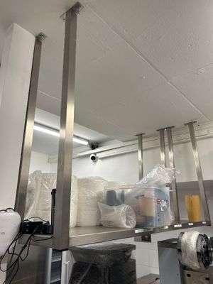 une photo d'une cuisine professionnelle avec des étagères en acier inoxydable