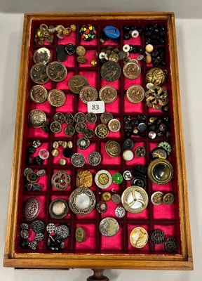 une boîte en bois remplie d'une multitude de boutons et de broches
