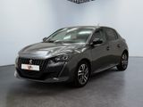 La voiture grise est garée dans une grande pièce au sol noir.