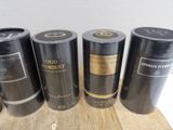four black tins of different types of perfume sitting on a wooden table