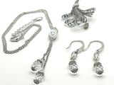 a necklace, earrings, and bracelet set on a white surface