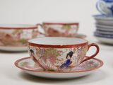 several cups and saucers sitting on top of a white table