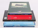 trois livres empilés sur une surface blanche
