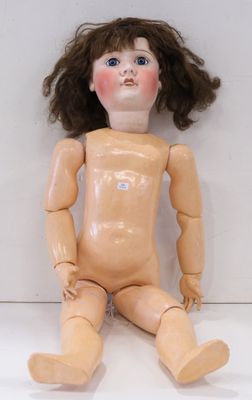 une petite poupée assise par terre sur un fond blanc