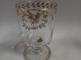 a glass cup with a gold design on it