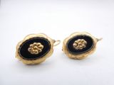 pair of black and gold earrings with flower design