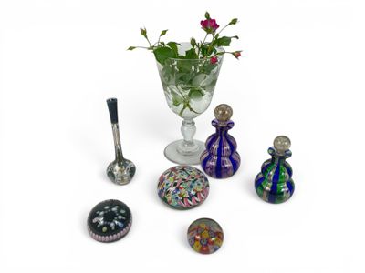 a glass vase with flowers in it next to other glass objects