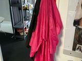 a red umbrella hanging on the wall next to a coat rack