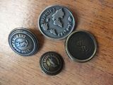 three different types of metal buttons on a wooden surface