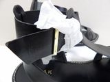 a close up of a pair of black sandals with a white bow on it