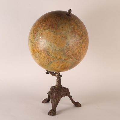 an antique globe on a tripod stand on a white background