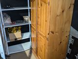 a tall wooden cabinet in the corner of a room