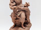 statue représentant une femme tenant un enfant sur un rocher, un oiseau dans la main