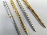 three different types of pens sitting on top of a white surface