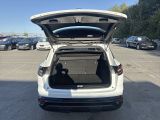 the back of a white car with its trunk open in a parking lot