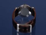 wrist watch on a blue surface with a reflection on the surface