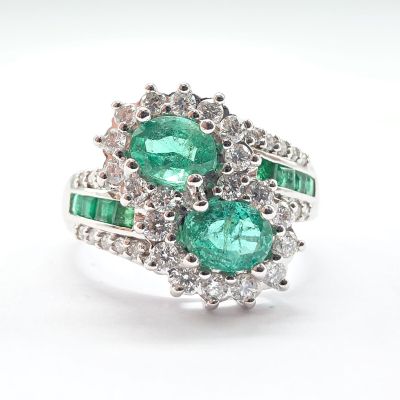 une photo en gros plan d'une bague sertie d'émeraudes et de diamants