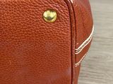 brown leather suitcase sitting on top of a wooden table