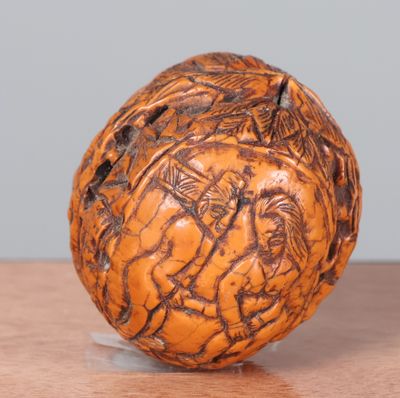 une boule en bois ornée de sculptures, posée sur une table