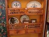 une étagère en bois sur laquelle sont posées des assiettes, dans une pièce