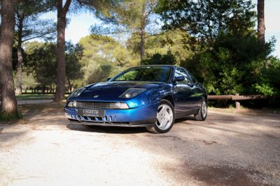 une voiture bleue garée sur la terre battue