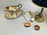 a table with a lamp, a saucer, and some nuts on it