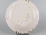 underside view of a white plate on a metal stand