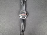 a close up of a watch on a table with a black background