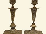 pair of antique brass candlesticks with ornate designs on bases