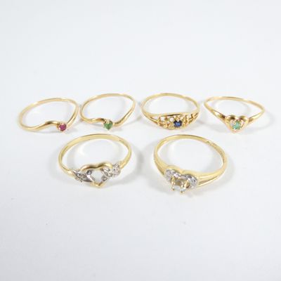 a group of five gold rings with different colored stones