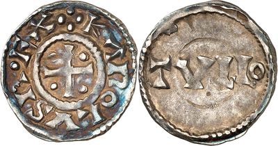 a close up of a silver coin with a cross on it