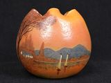 un vase orange orné d'une image représentant un paysage de montagne