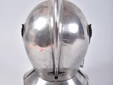 a silver object with a helmet on it on a white surface