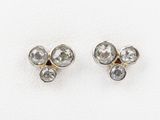 une paire de boucles d'oreilles en diamant sur une surface blanche