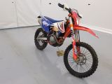 une moto tout-terrain rouge et bleue garée dans une pièce