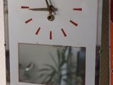 a clock that is sitting on a shelf next to a book