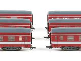 two red and gray train cars sitting side by side