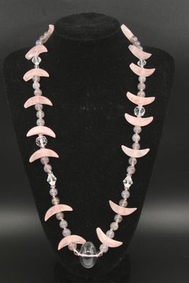 un collier composé de perles roses et blanches sur un mannequin noir