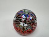 une boule en verre ornée d'un motif, posée sur une surface blanche