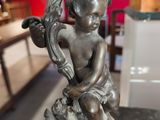 a statue of a little boy sitting on a pedestal