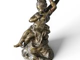 une image représentant la statue d'un garçon assis sur un rocher